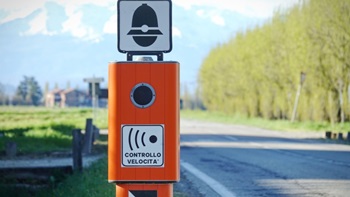 Autovelox su strada deserta con alberi